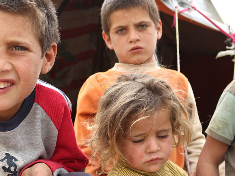 Kinder in einem Flüchtlingslager in Syrien halten eine Solarlampe in der Hand.