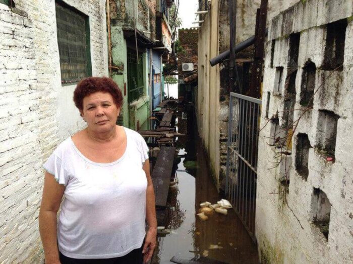 Eine Frau steht im Hochwasser vor ihrem Haus in Paraguay