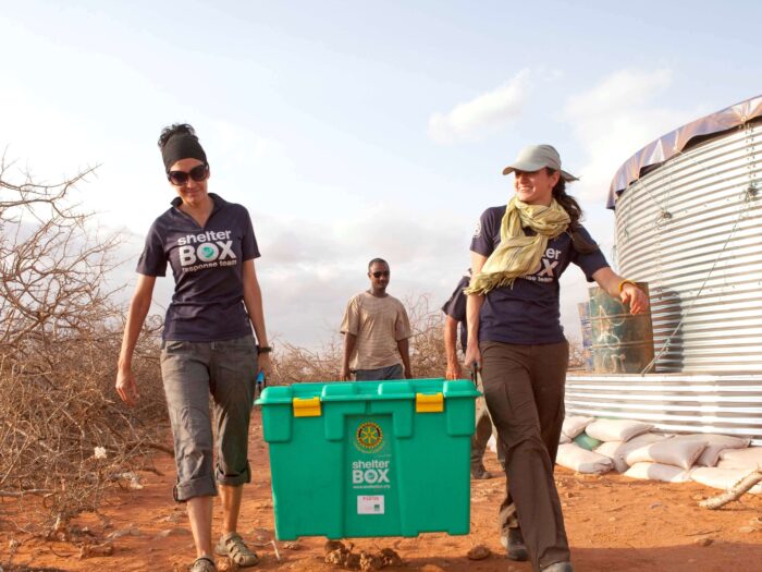 ShelterBox Response Team Mitglieder tragen eine ShelterBox im Haloweyn Geflüchtetenlager in Äthiopien
