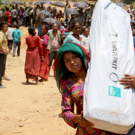 Eine Frau mit einem Shelterbox-Kit in Nepal