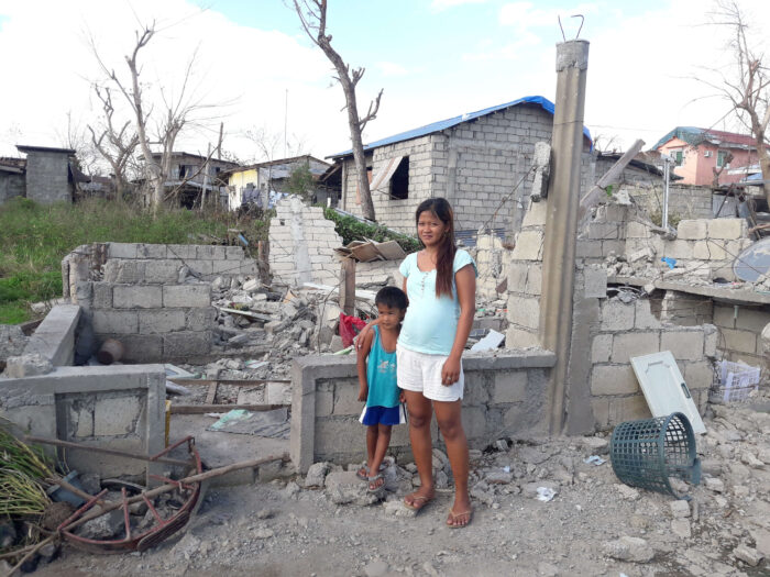 Mutter uns Sohn stehen vor den Trümmern ihres Zuhauses, das vom Taifun Mangkhut zerstört wurde