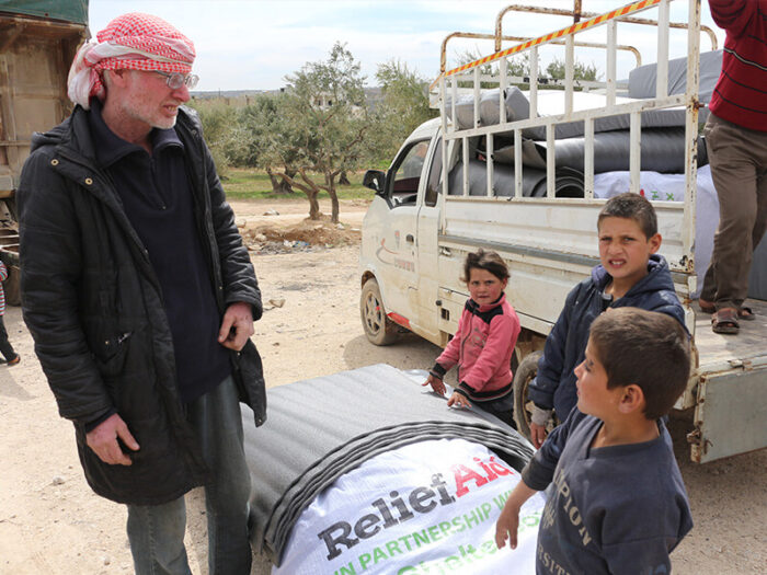 Eine Familie erhält Werkzeuge, um eine Unterkunft zu bauen.