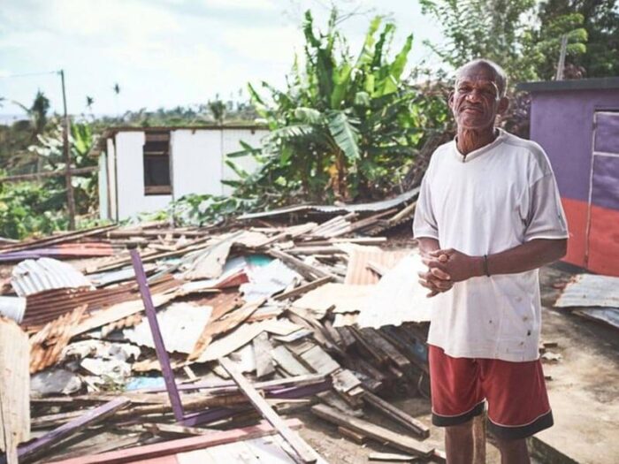 A man standing in front of a collapsed building