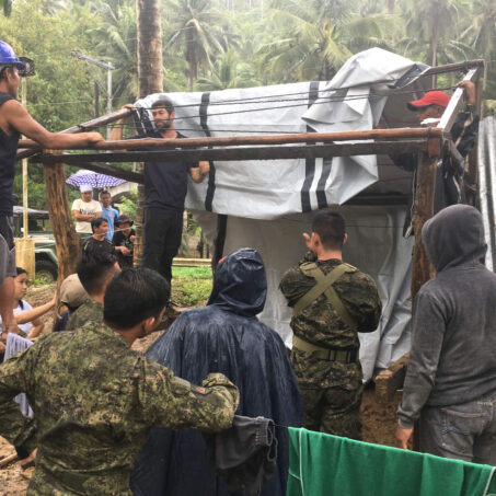 Personen bauen eine Unterkunft nach dem Tropensturm auf den Philippinen