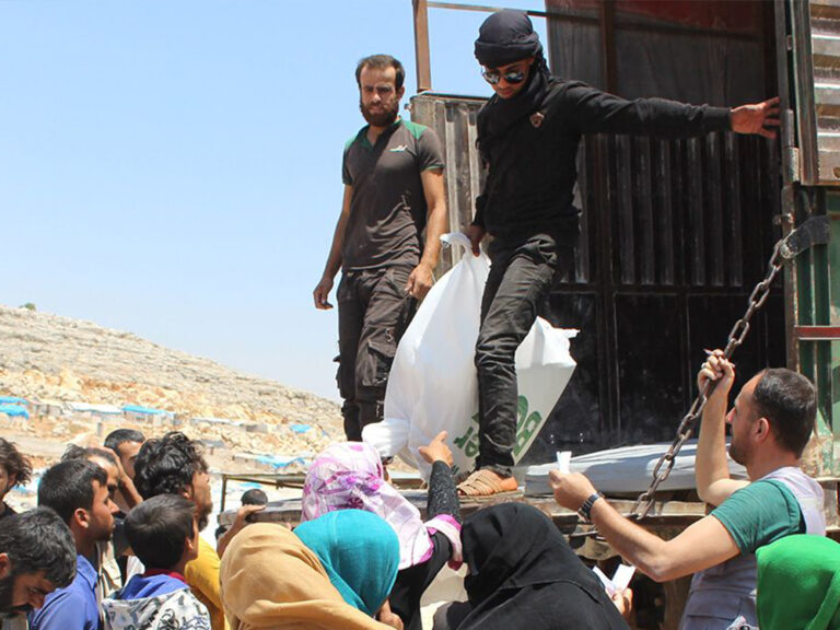 Helfer:innen in Syrien auf der Ladefläche eines Lastwagens