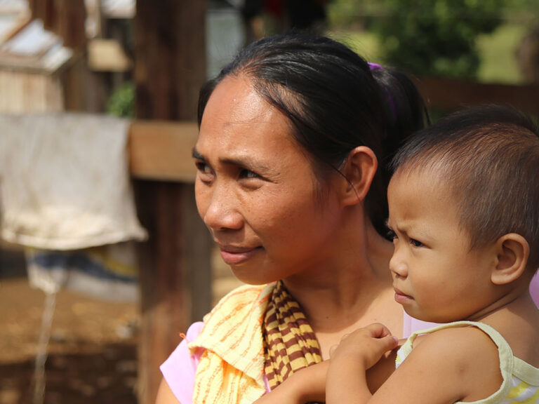 Eine Frau mit ihrem Sohn im Arm in den Philippinen