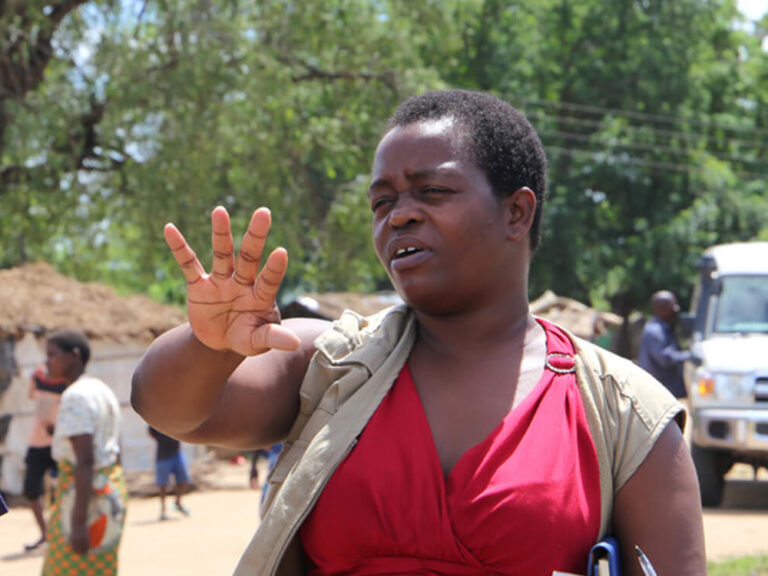 Drei Menschen sprechen miteinander in Malawi