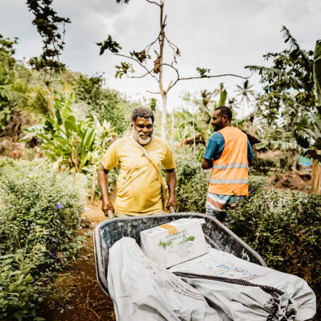 Ein Mann schiebt eine Schubkarre mit Notfallausrüstung in Vanuatu während des Zyklons Harold