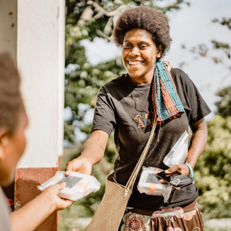 Eine Frau verteilt Solarlampen in Vanuatu nach dem Zyklon Harold