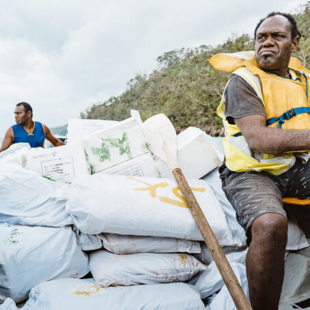 Zwei Männer transportieren ShelterBox Hilfsgüter per Boot nach Vanuatu