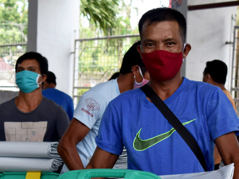 Mann mit Maske auf den Philippinen, der Hilfe von ShelterBox erhält