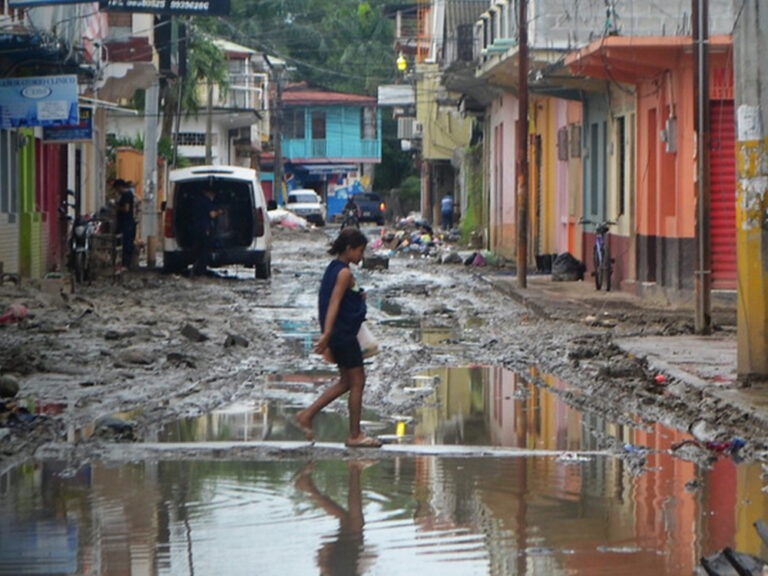 Eine Frau läuft durch überschwemmte Straßen in Honduras