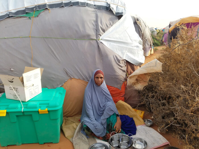 woman sat down next to a green box