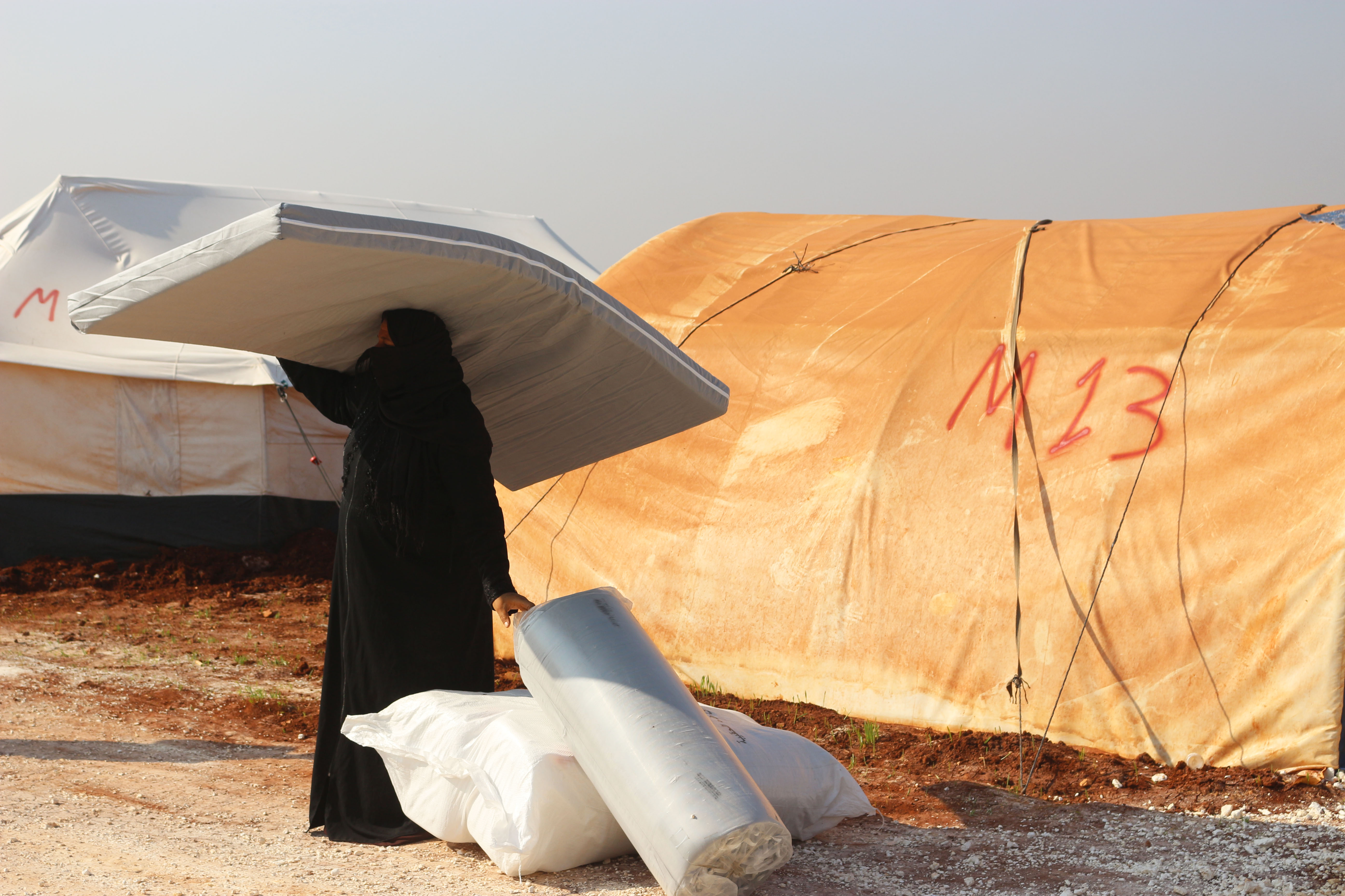 Binnenvertriebene: Eine Vertriebene Frau im Norden Syriens erhält Hilfsgüter von ShelterBox