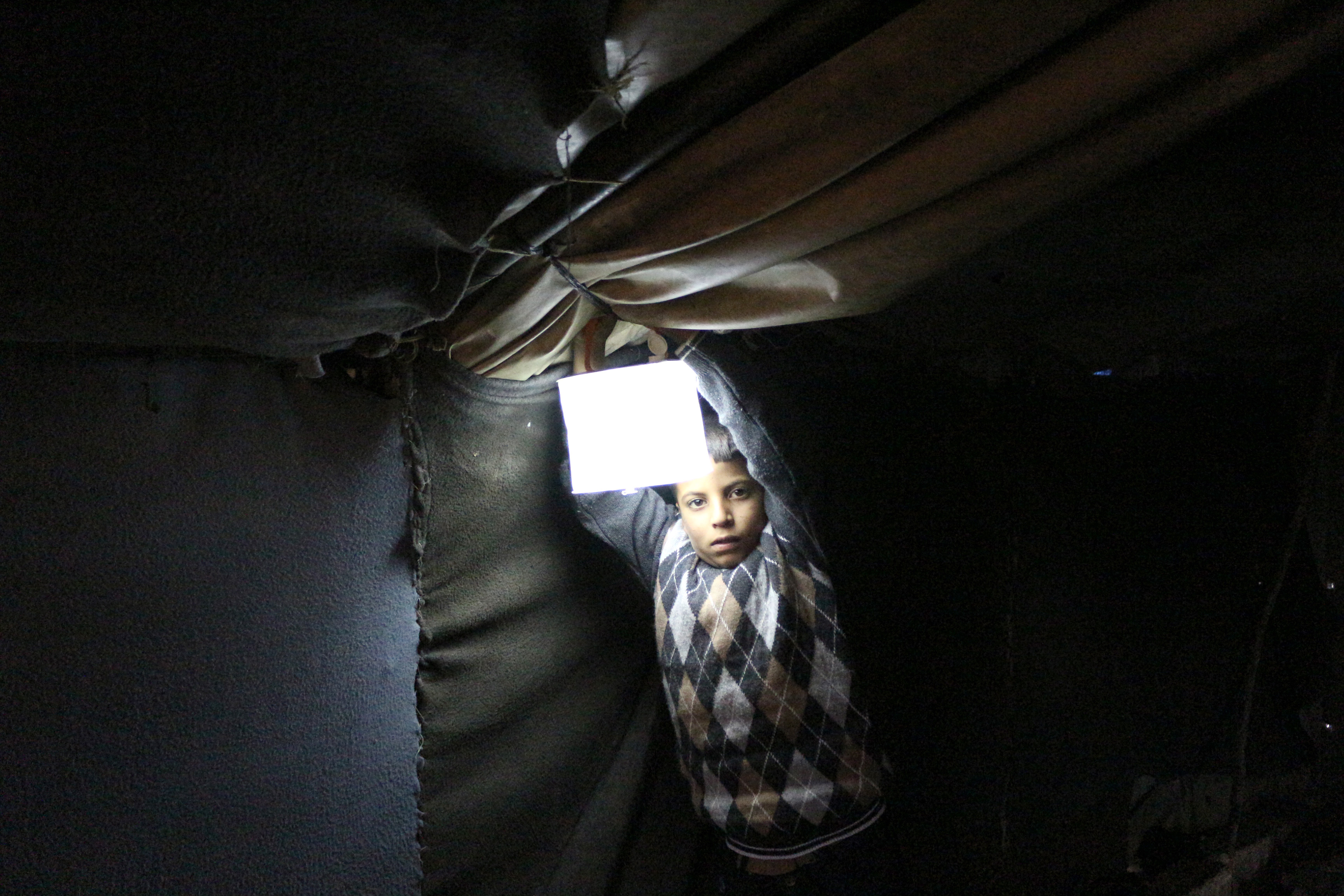Binnenvertriebne: Ein Kind in Syrien mit einer Solarlampe von ShelterBox