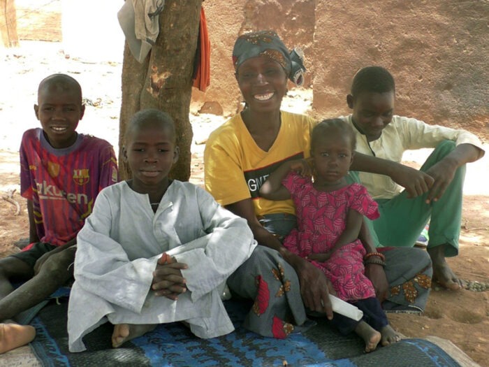 Frau lächelt, umgeben von Kindern