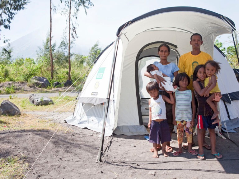 Eine sechsköpfige Familie steht vor einem ShelterBox Zelt in den Philippinen
