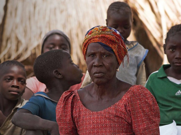 Eine Frau und Kinder sitzen in einer Unterkunft
