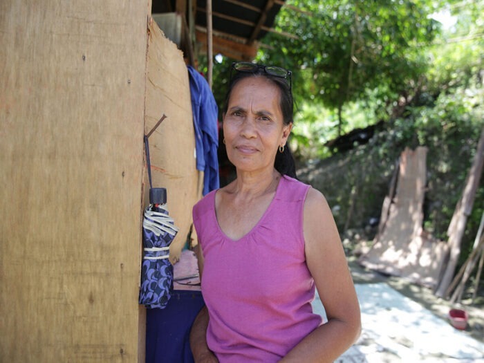 Violeta steht vor ihrem Zuhause in Cebu und blickt in die Kamera