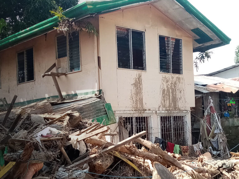 Ein von Trümmern umgebenes Haus nach einem Tropensturm in den Philippinen