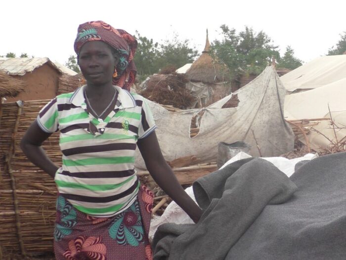 Eine Frau steht neben einer Unterkunft in Kamerun