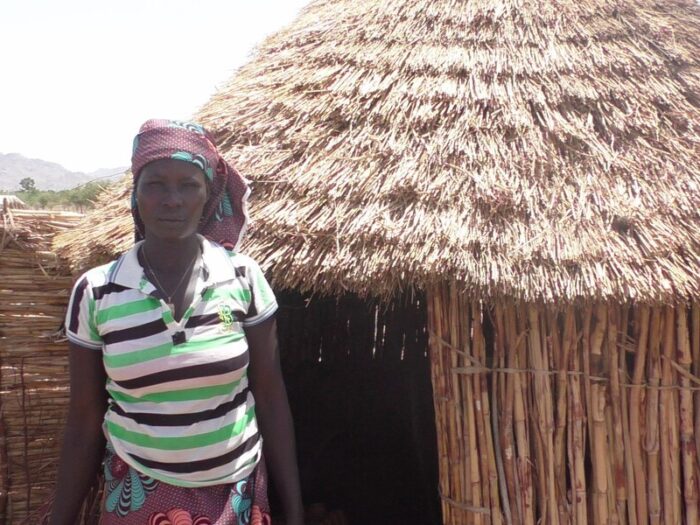 Eine Frau steht neben einem Haus in Kamerun