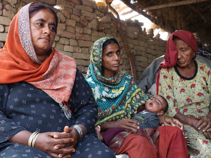 Three women, one holding a baby
