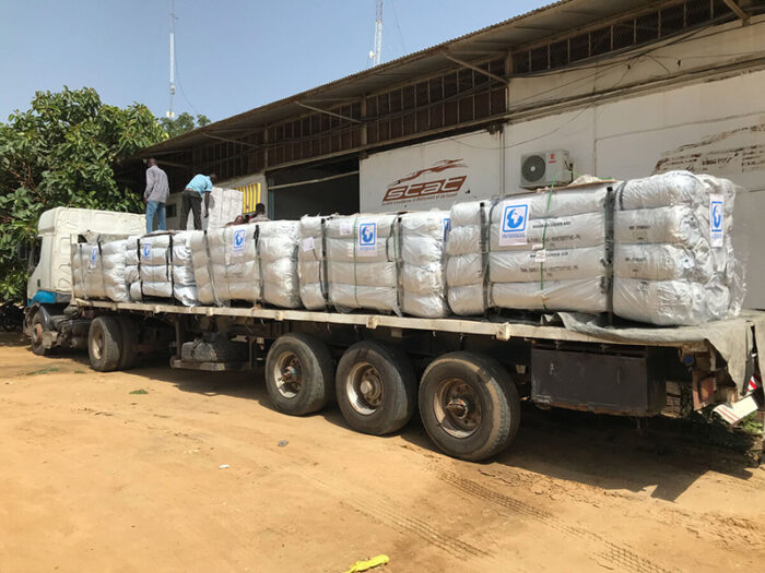 A lorry with aid materials parked outside a warehouse