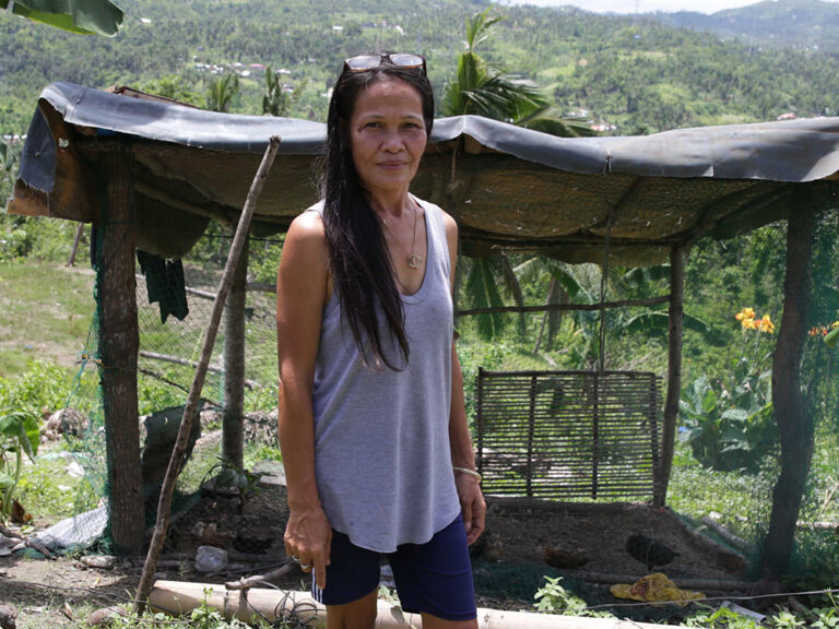 Eine Frau steht neben einem beschädigten Haus nach einem tropischen Sturm in Vanuatu