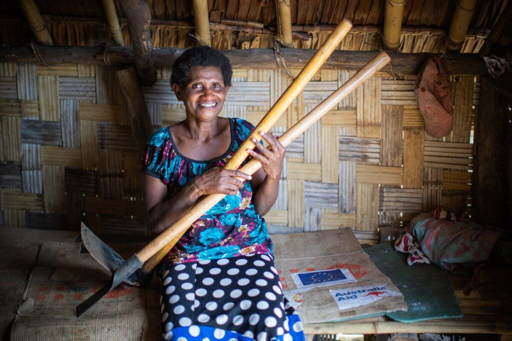 Frau mit landwirtschaftlichen Werkzeugen in einer Unterkunft in Vanuatu