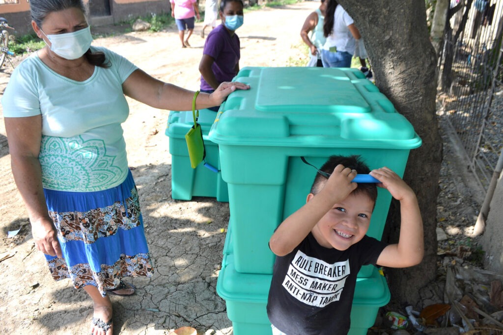 Frau und Kind mit einer großen grünen Kiste mit Hilfsgütern von ShelterBox nach den Hurrikanen in Honduras