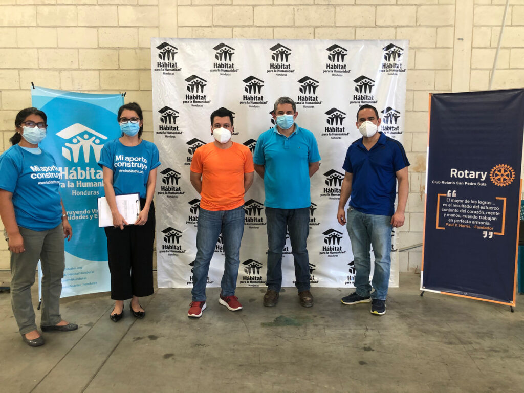 Teammitglieder von Rotary International und Habitat for Humanity vor einer Ausstellungstafel