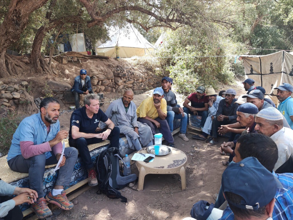 Eine Gruppe Menschen sitzt und unterhält sich im Atlasgebirge in Marokko nach dem Erdbeben dort