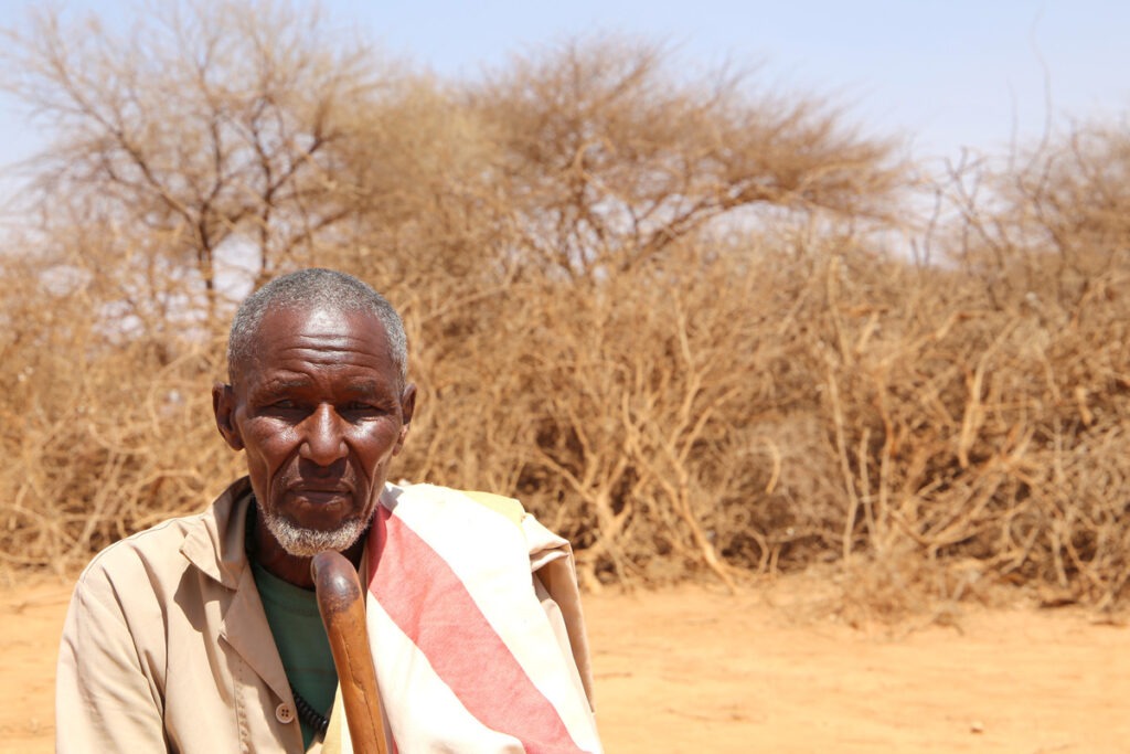 Ein Mann saß mit seinem Gehstock in dem von Dürre heimgesuchten Somaliland.