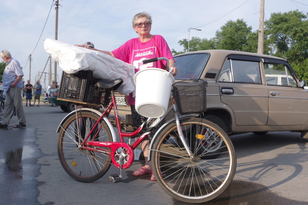 Eine Frau in der Ukraine transportiert Hilfsgüter mit einem Fahrrad
