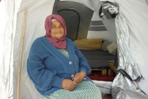 Eine Frau sitzt im Eingang eines Zeltes in Marokko