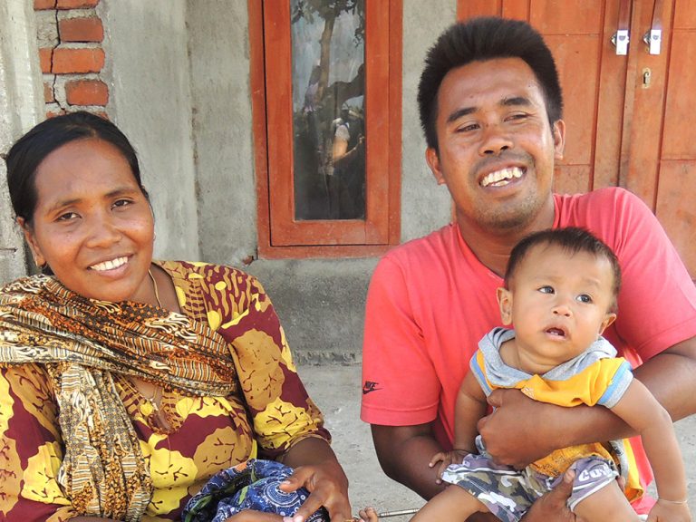 Man, woman and child sitting on the floor in Indonesia