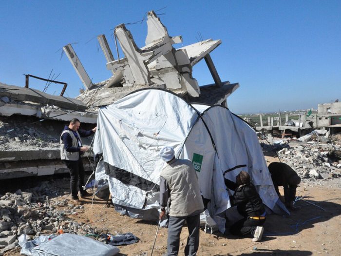 Ein Zelt wird neben einem zerstörten Gebäude in Gaza aufgestellt