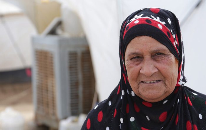 Woman in headscarf outside a tent in Iraq