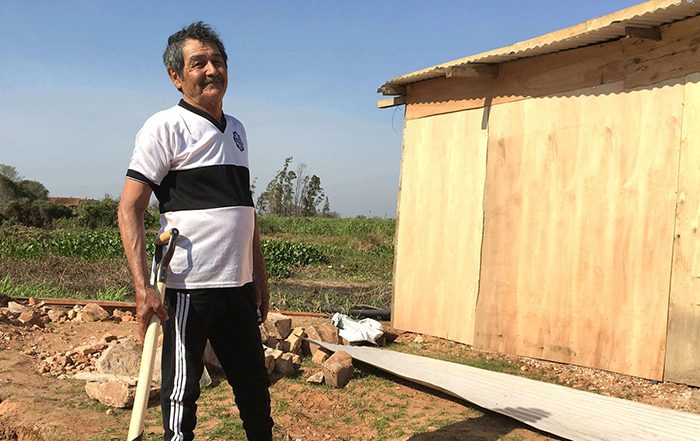 Man holding shovel outside a home in Paraguay