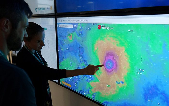 People monitoring a storm on a screen