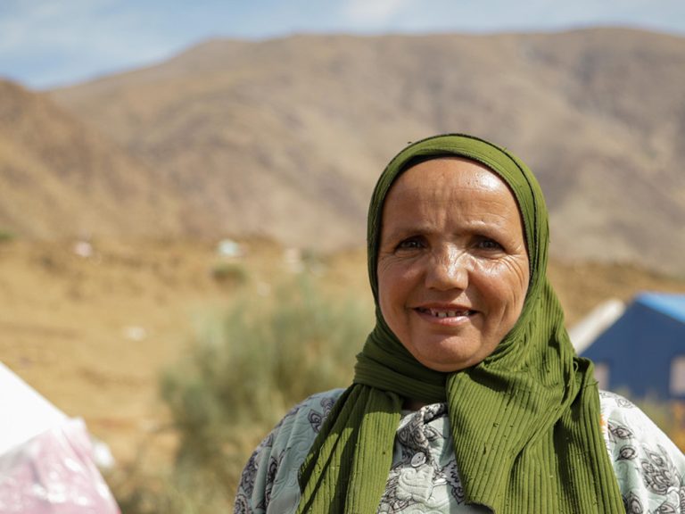 Eine Frau steht neben Zelten im Atlasgebirge in Marokko