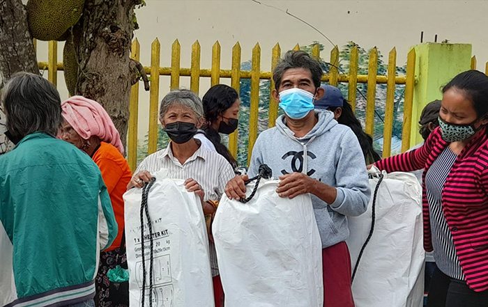 People wearing facemasks holding aid in the Philippines