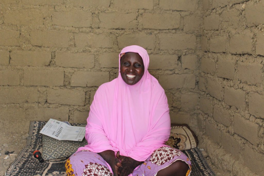Frau sitzt in einer gemauerten Unterkunft in Kamerun
