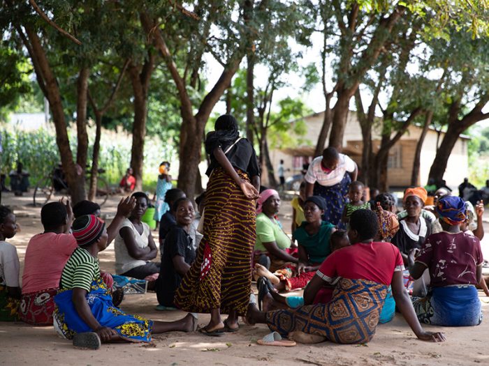 Eine Gruppe Menschen sitzt in Malawi auf dem Boden