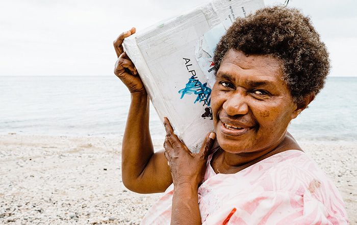 Woman carrying bag of aid in Vanuatu