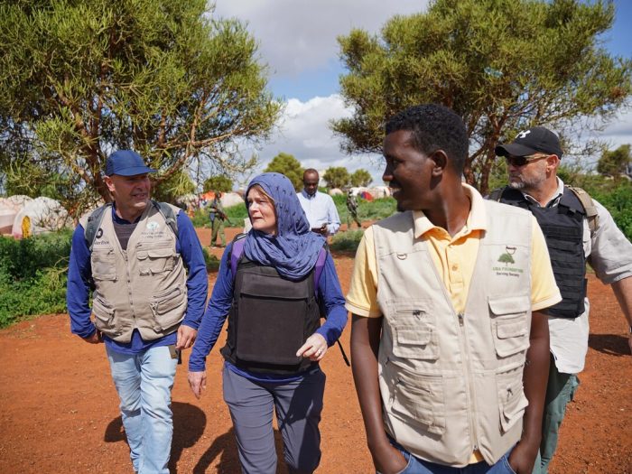 Eine Gruppe an Menschen geht durch ein Vertriebenenlager in Somalia